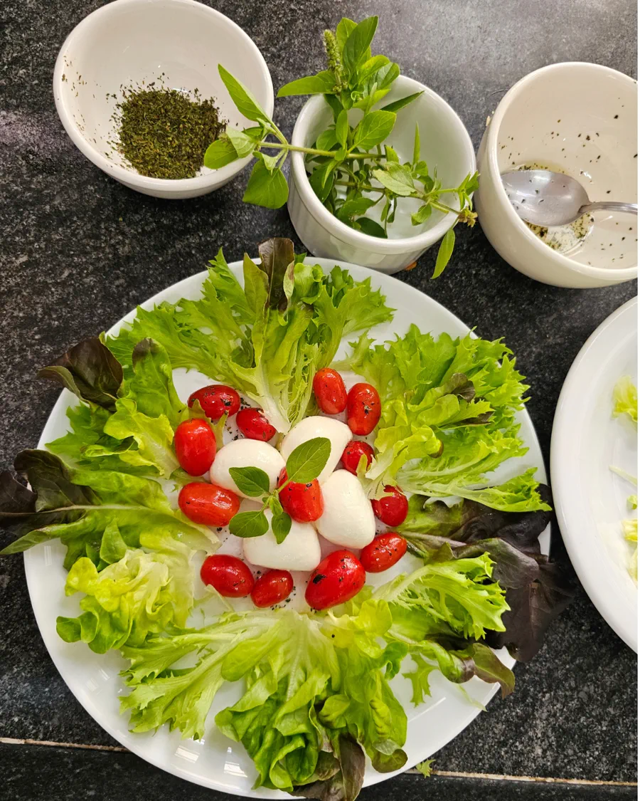 Ciranda da Bailarina: prato branco com folhas de alface em coroa, tomates-cereja e bolinhas de muçarela de búfala
