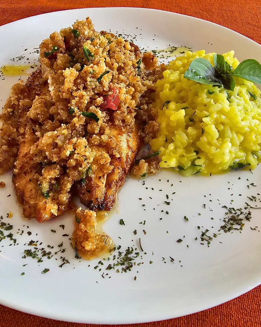 Reverência: filé de truta coberto de farofa dourada ao lado de risoto amarelo de açafrão