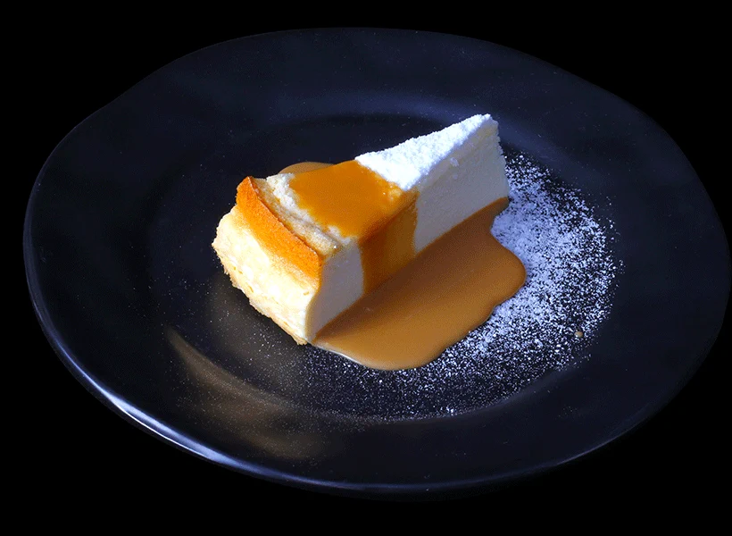 Chuvisco de Olívia: fatia de torta de ricota com calda de doce de leite em prato preto